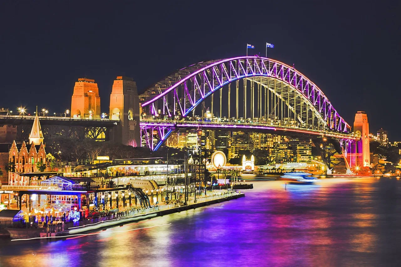 Sydney Harbour Bridge illuminated over the waterfront at night